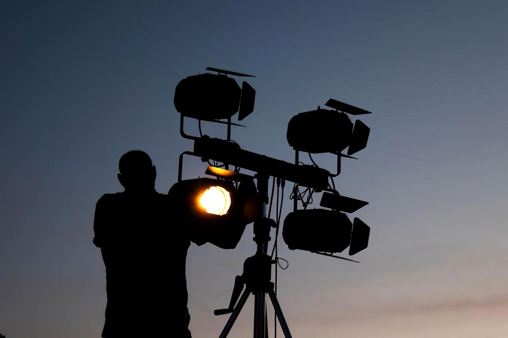Technician installing modern smart lighting in a living room