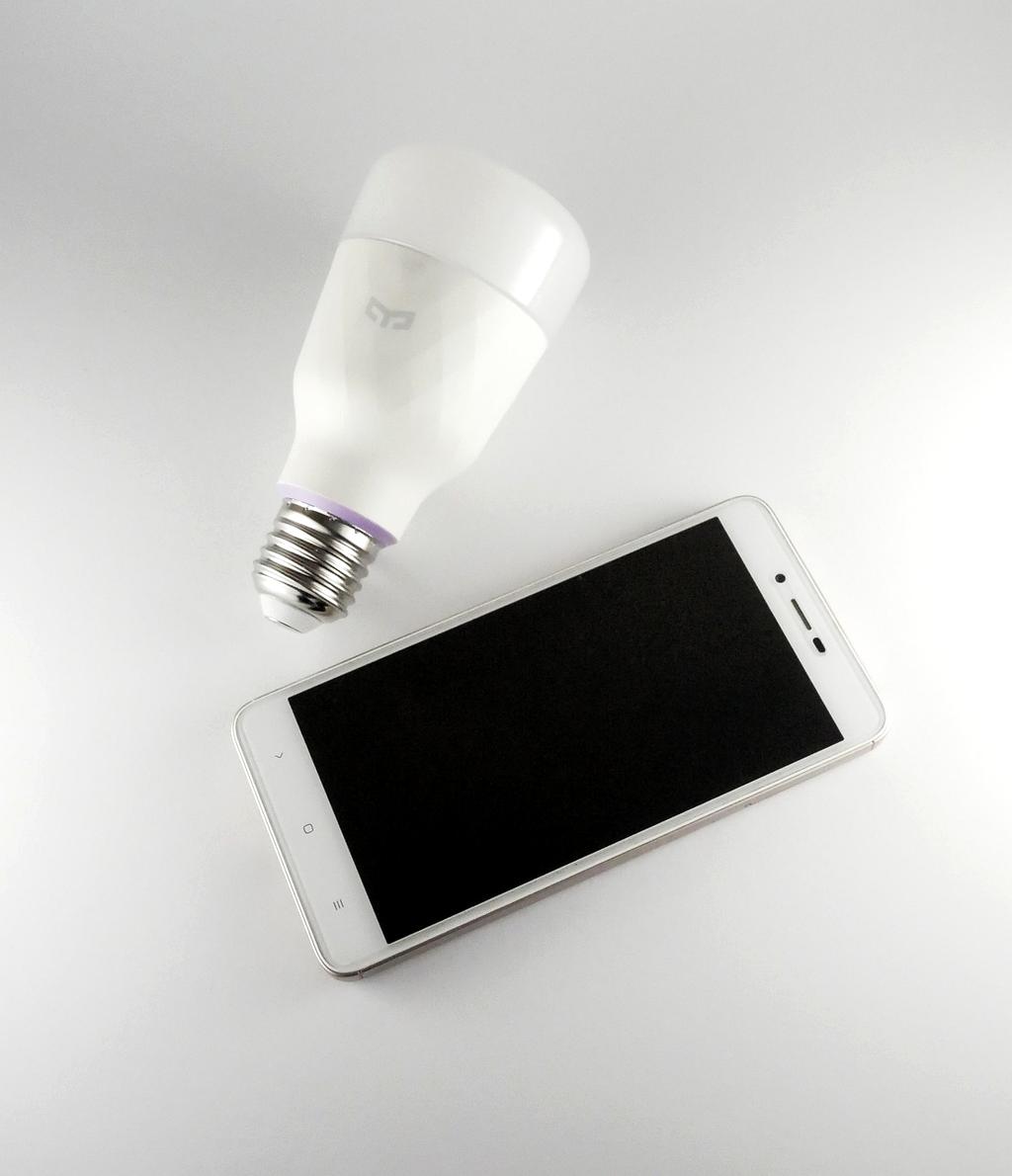 Smart bulb being controlled via smartphone app showing color temperature adjustment