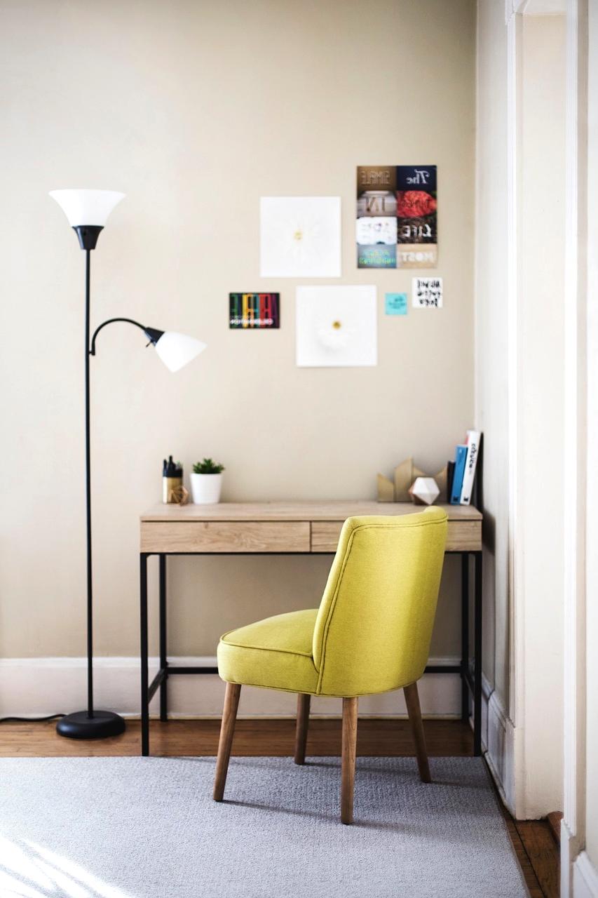 Table lamp casting soft light next to a book and cup of tea